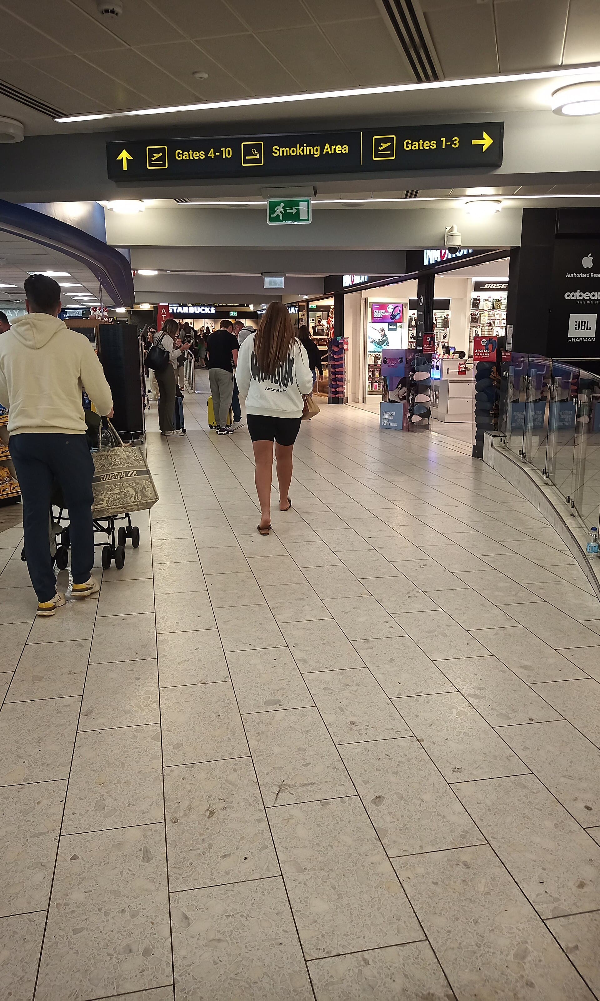 Travelers walking through an airport departures concourse